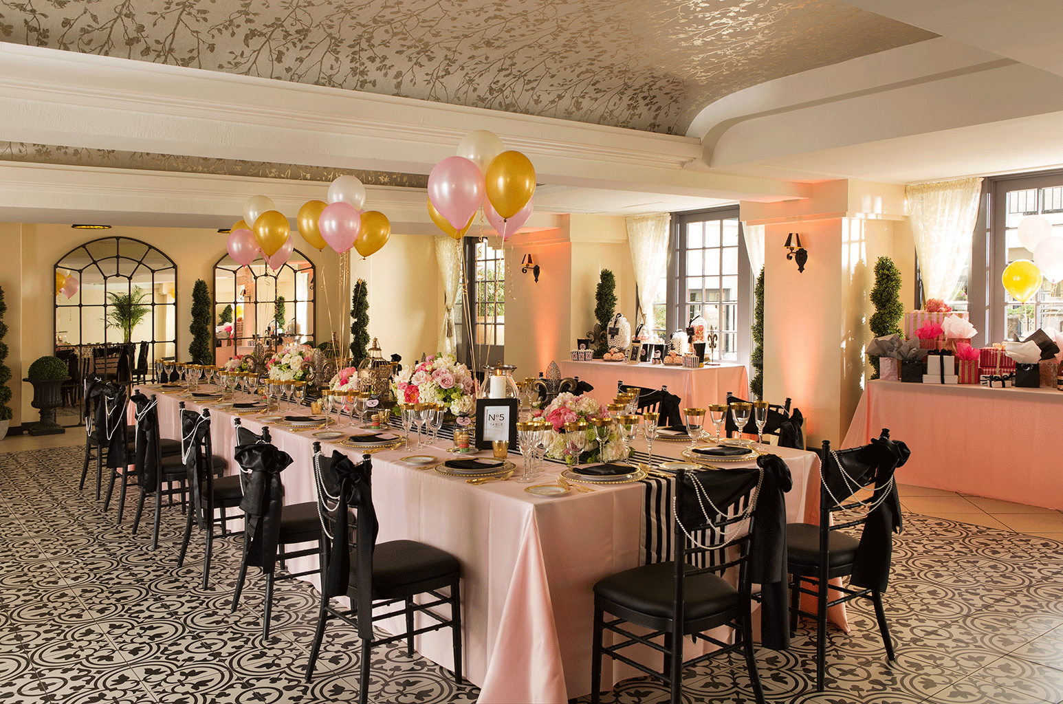decorated ballroom with table, chairs, flowers and balloons