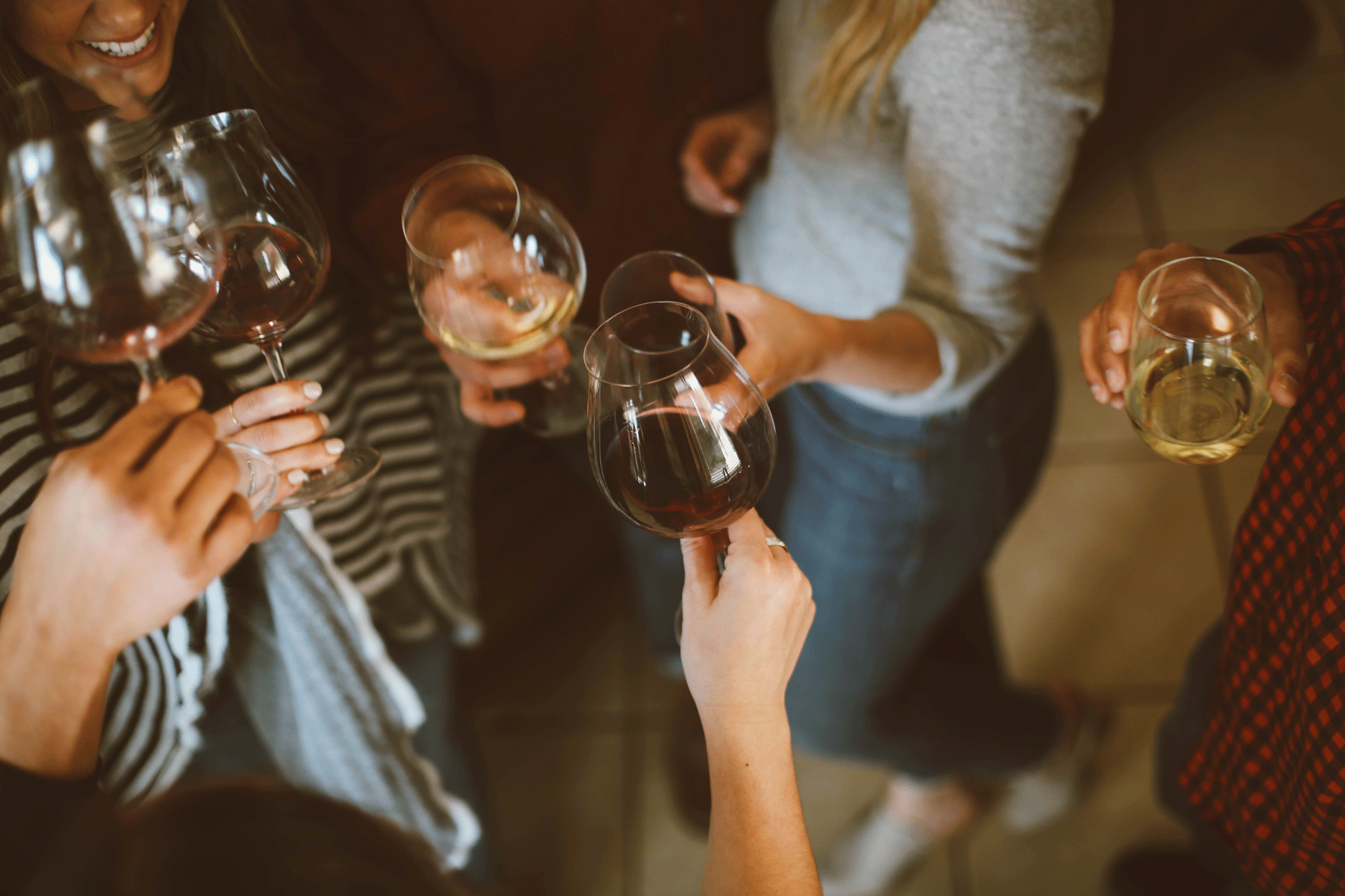 women holding wine glasses and smiling