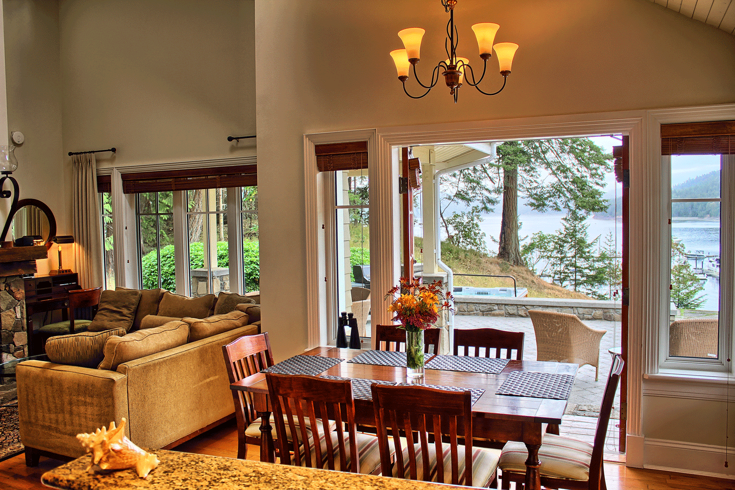 dining table next to open doors that overlook ocean