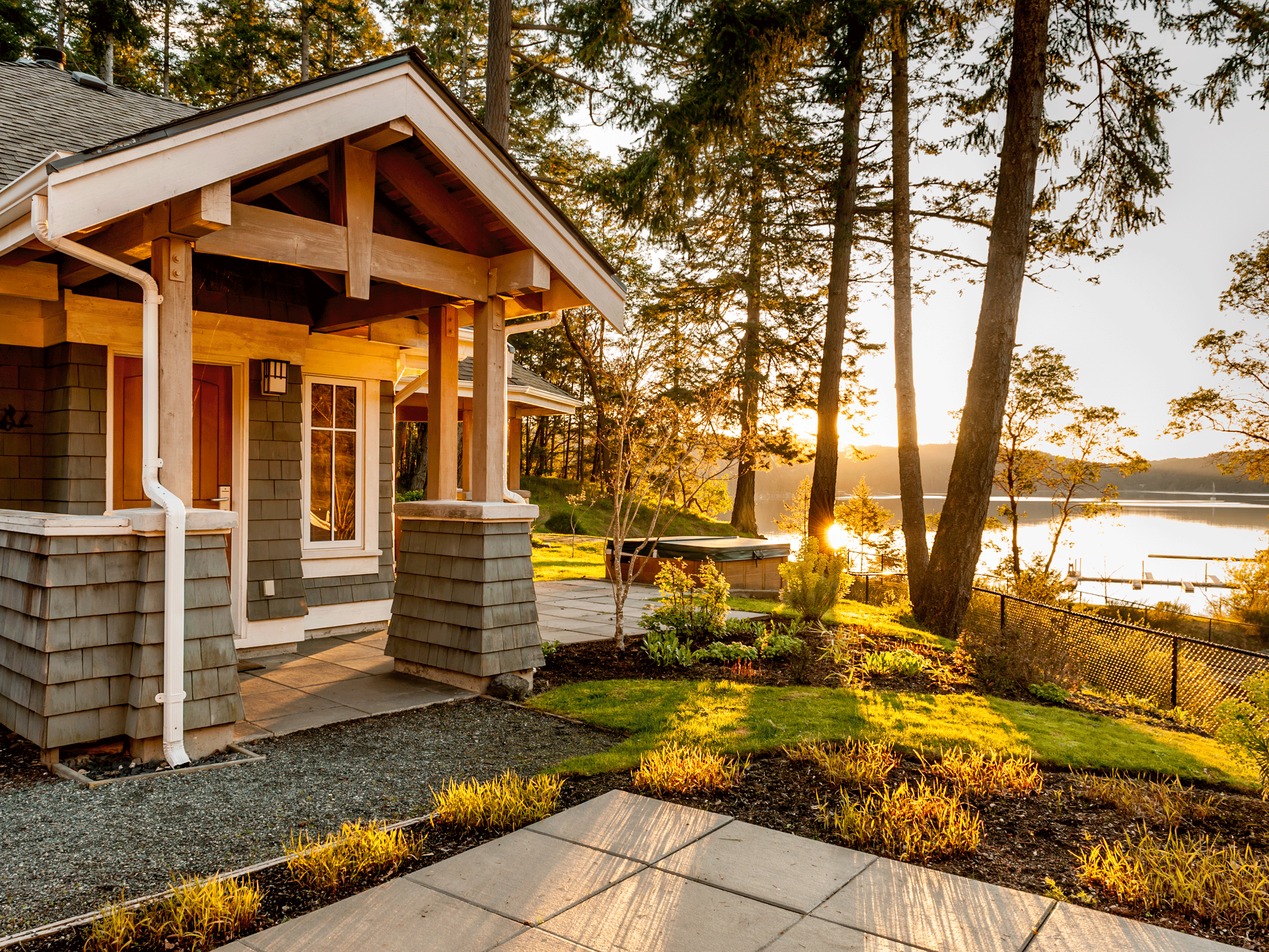 red cottage with woods and water in the background