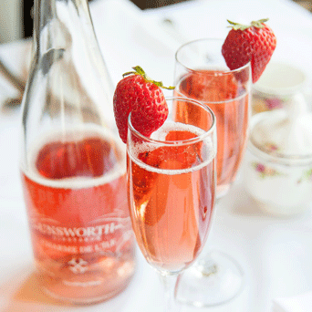 Bottle of Unsworth sparkling wine and glasses of champagne in Pendray Tea House at Pendray Inn & Tea House