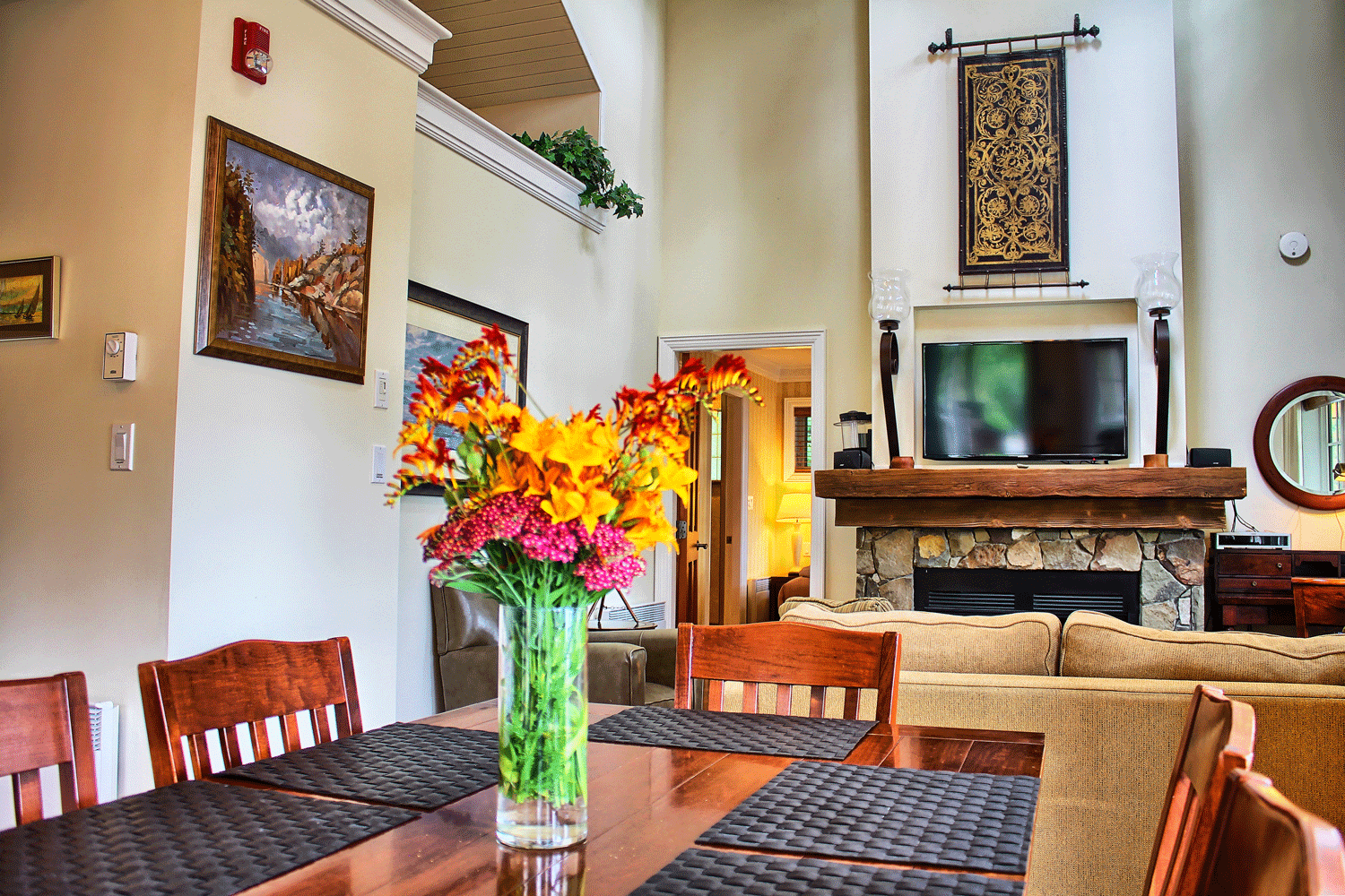 flowers on dining table next to fireplace and tv