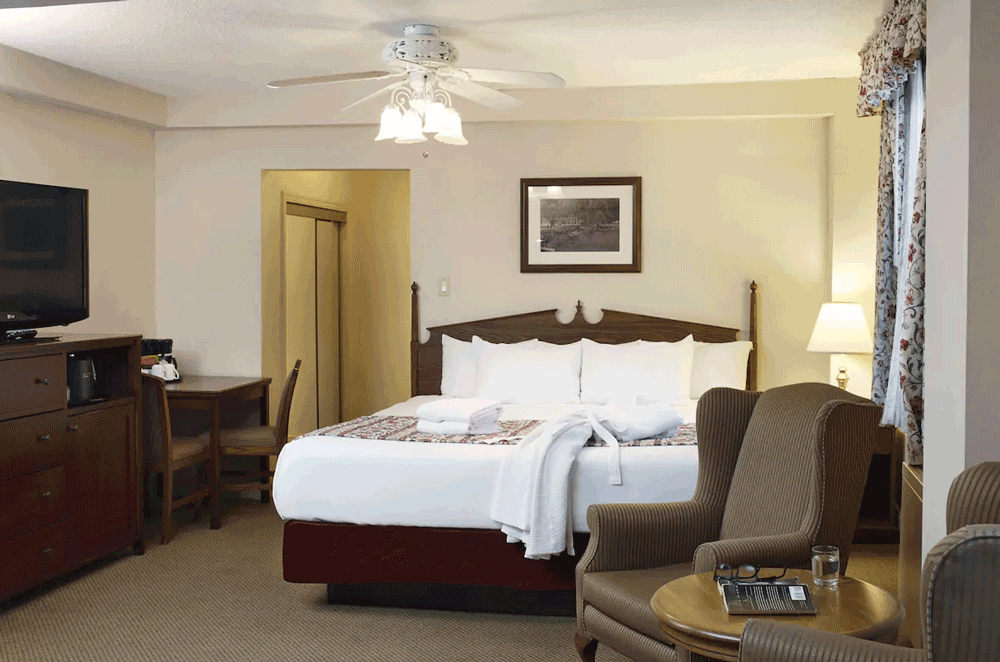 Heritage Building: Family Room with bed, cozy chairs and a TV at Harrison Hot Springs Resort