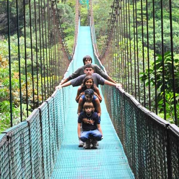 Family on a suspension bridge near Ficus Lodge