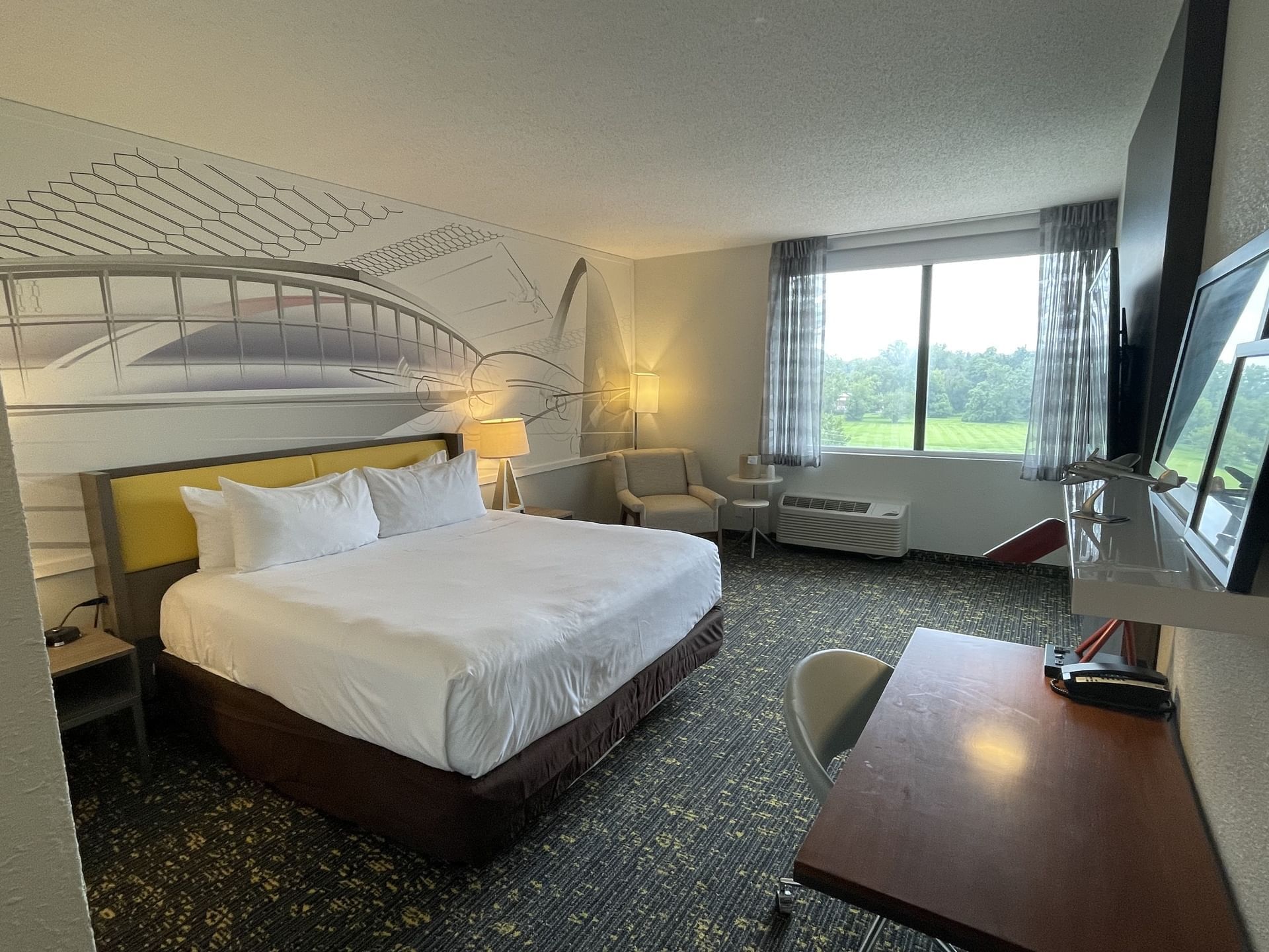 King bed, lounge area & workspace in Single King Standard at St. Louis Airport Hotel
