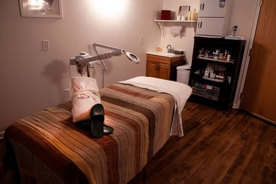 Treatment room with massage table, steamer machine, and skincare shelf in Moon Spa at La Tourelle Hotel and Spa