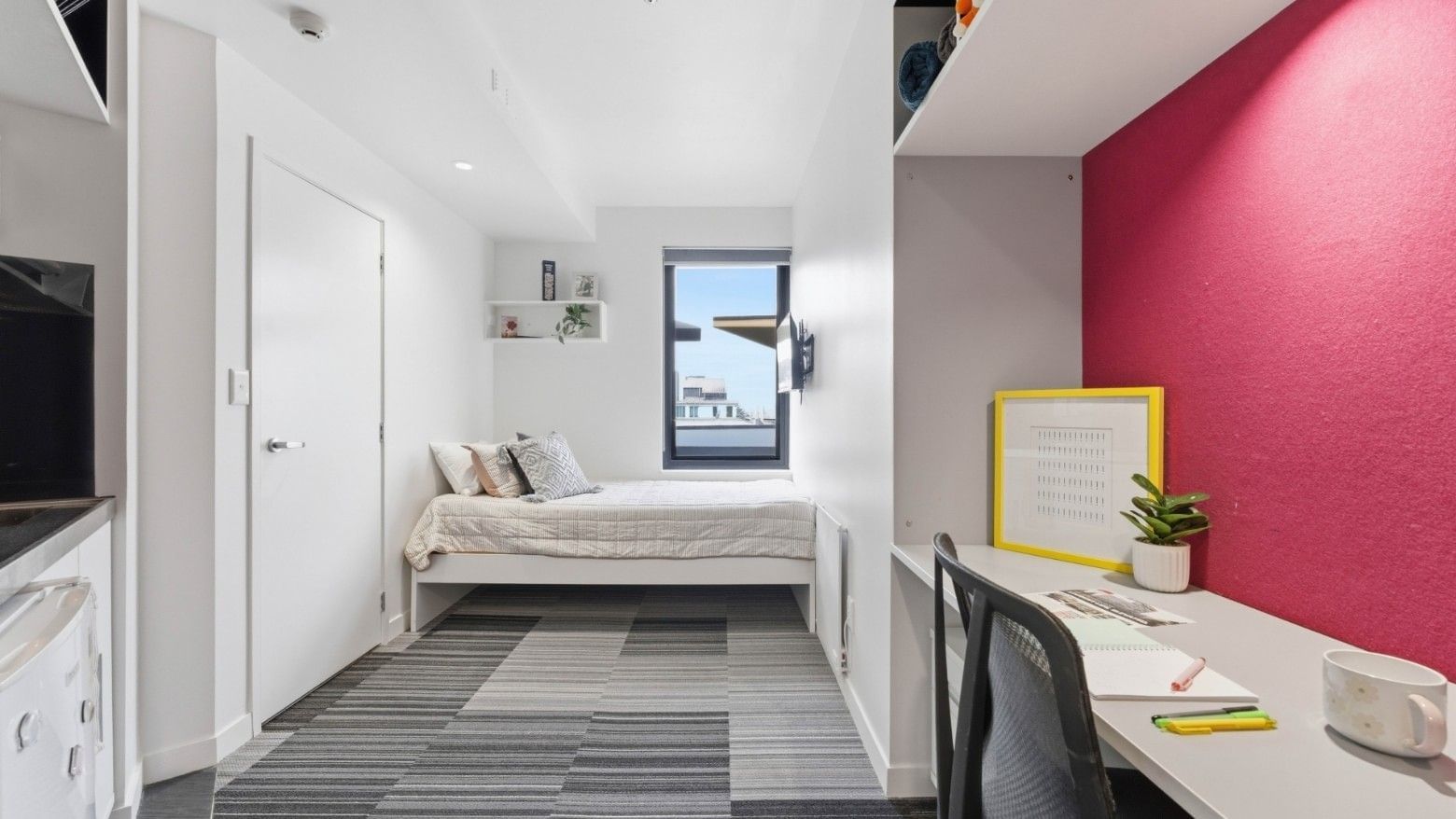 Clean bedroom with desk, bed, and window at UniLodge Auckland City.