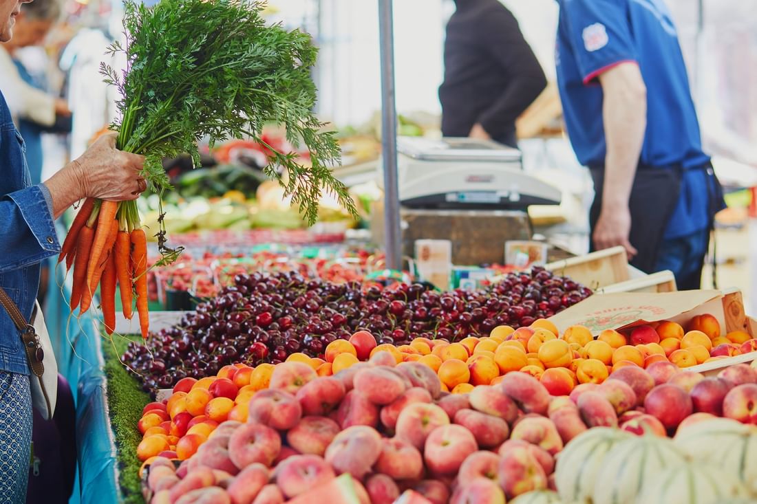 Étal de marché avec fruits frais et carottes à Lyon chez Warwick Reine Astrid-Lyon