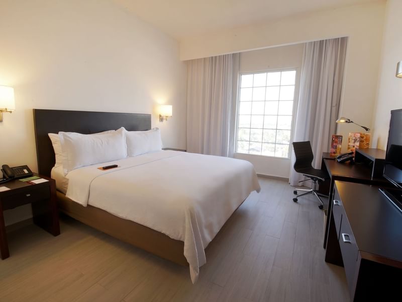 King bed with working desk in Accessible Room at Fiesta Inn