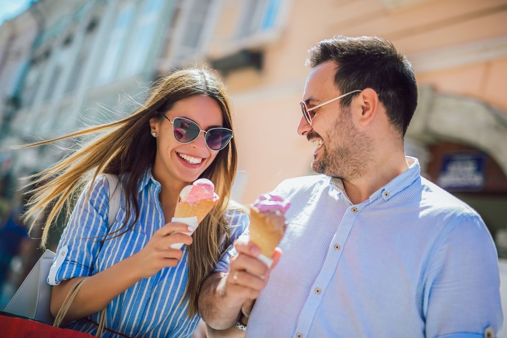 Couple by ice cream cones under bright sunlight surrounding the street near Warwick Paris Champs Elysées