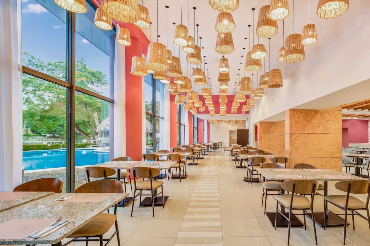 Mesas de comedor en un restaurante con vista a la piscina, Hoteles Fiesta Inn