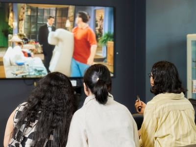 Three residents watching TV in a common area at Student Living - 800 Swanston.