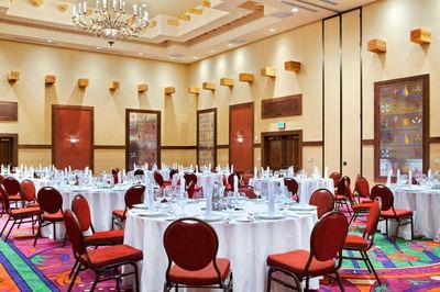 Grand ballroom at Hilton Santa Fe Buffalo Thunder set with round tables and red chairs for an event