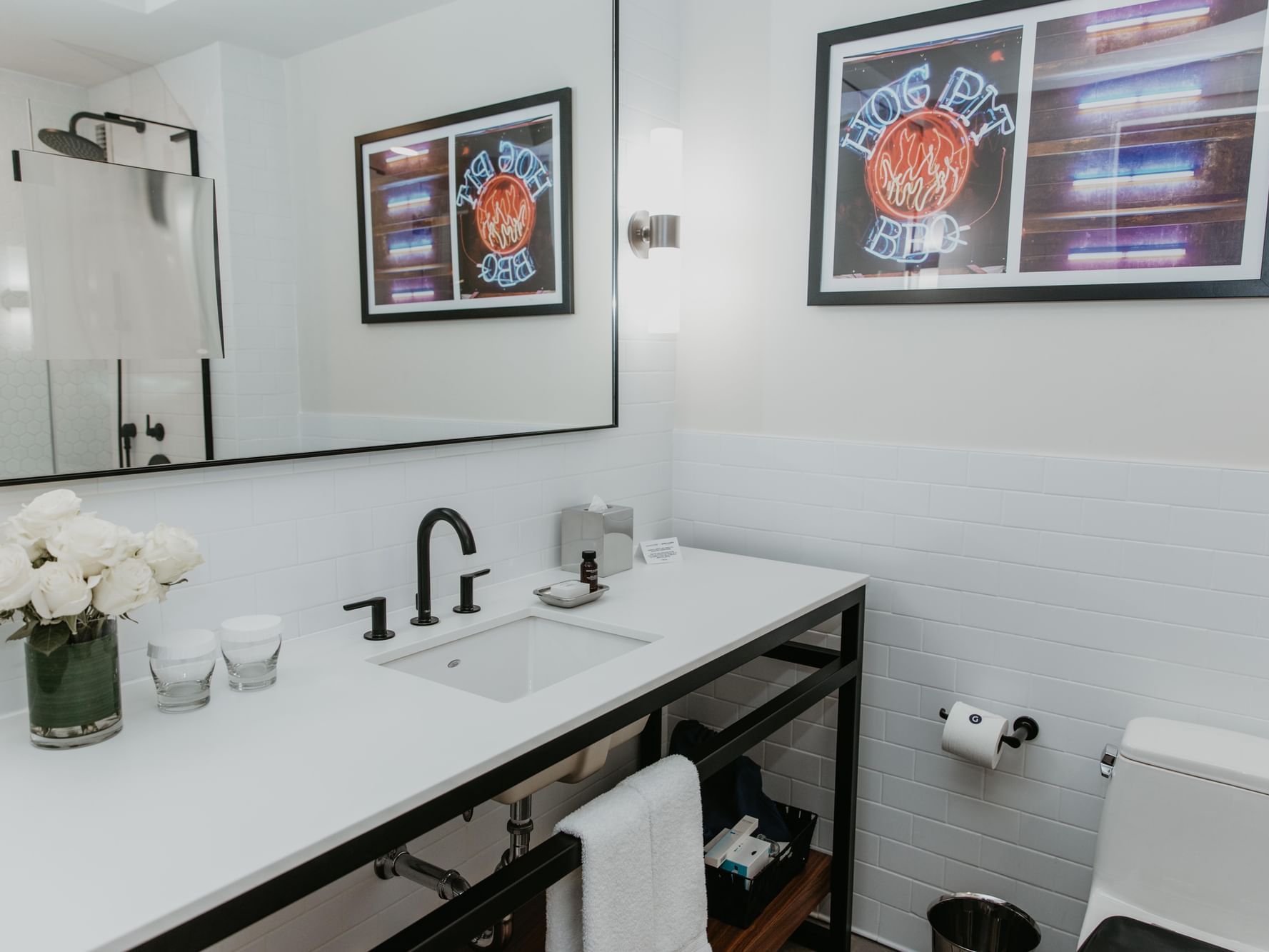 Modern bathroom sink with flower vase and framed art in Deluxe Room at Gansevoort Meatpacking NYC