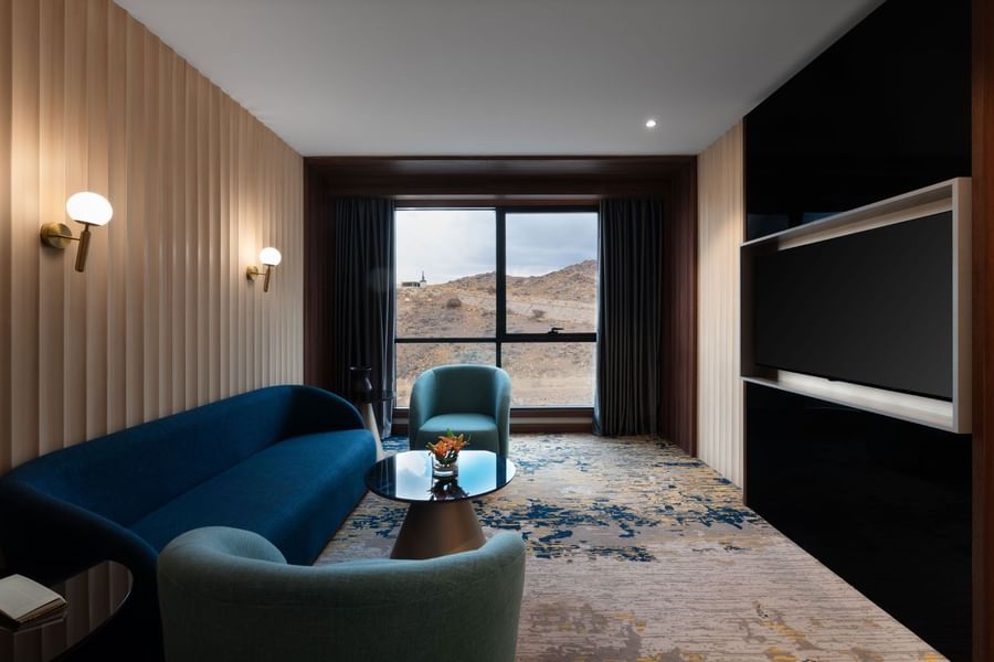 TV lounge with plush sofa by the window in Junior Suite at Warwick Al Taif Hotel