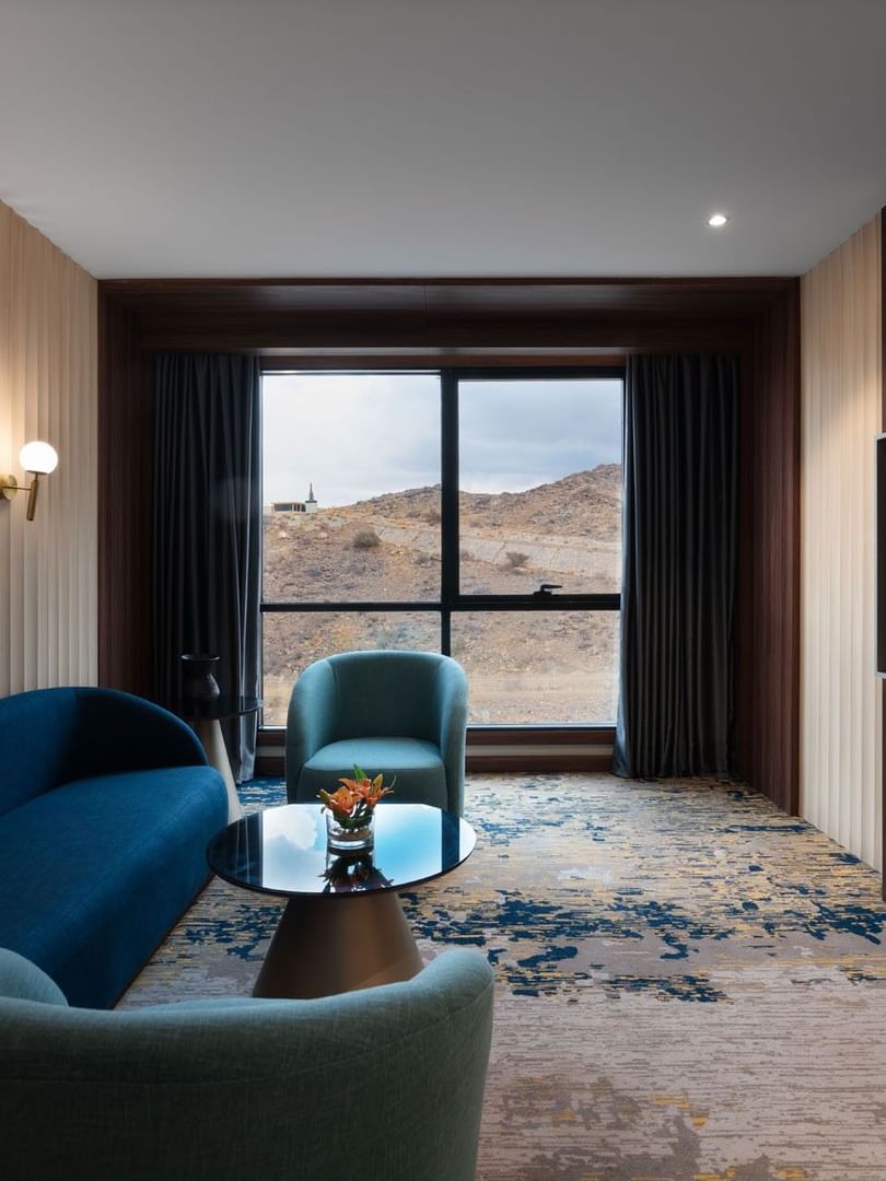 TV lounge with plush sofa by the window in Junior Suite at Warwick Al Taif Hotel