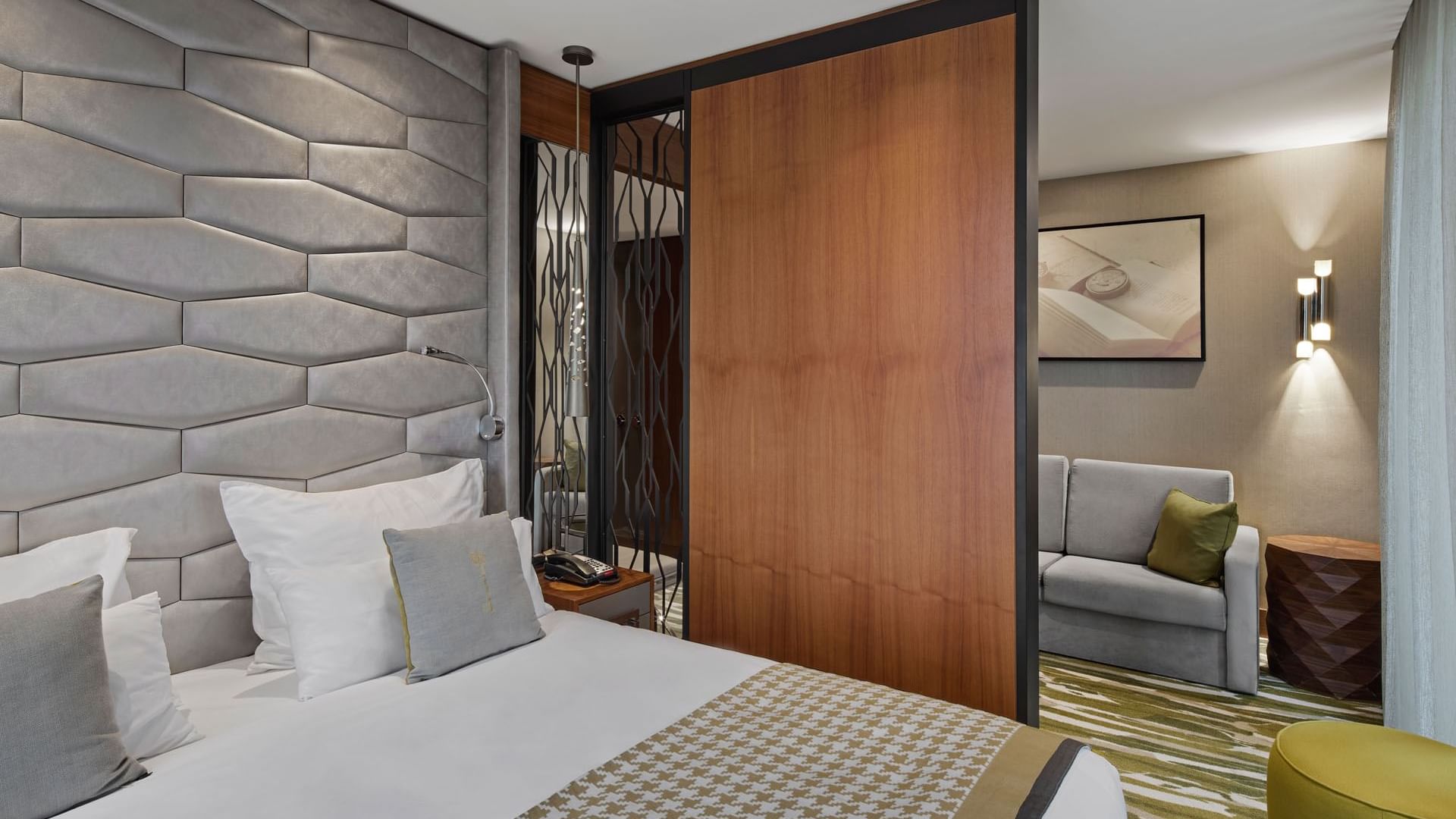 Gemütlicher Bett- und Loungebereich mit modernen Möbeln in der Junior Suite im Titanic Chaussee Berlin