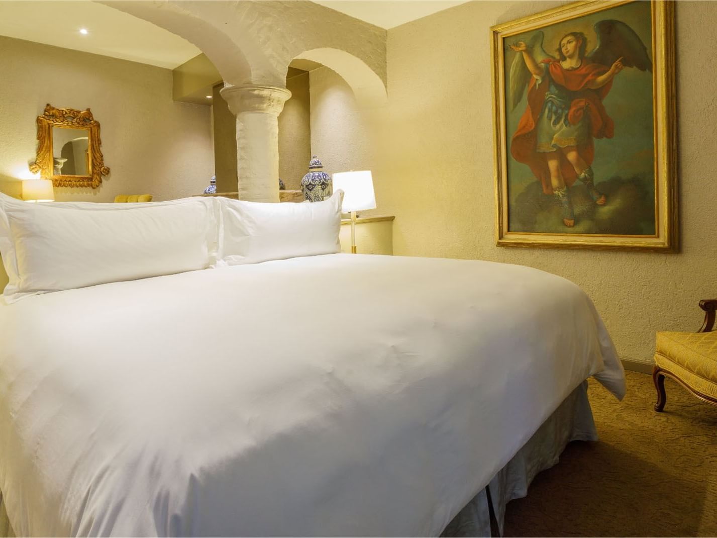King Governor Suite with stone arches and a large angel painting, at the luxury hotel Quinta Real Guadalajara