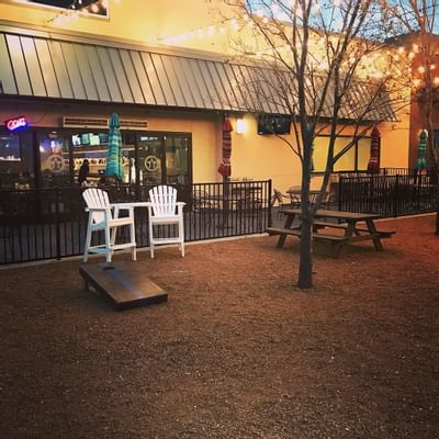 outdoor area with adirondack chairs and cornhole station
