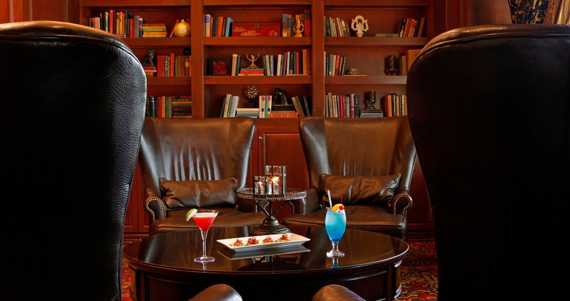 Lounge area with Wingback Chairs and cocktails served in The Library Bar at Warwick Melrose - Dallas