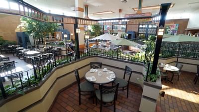 Balcony dining table with chairs, surrounded by railings, in Garden Court Restaurant at Glenmore Inn & Convention Centre