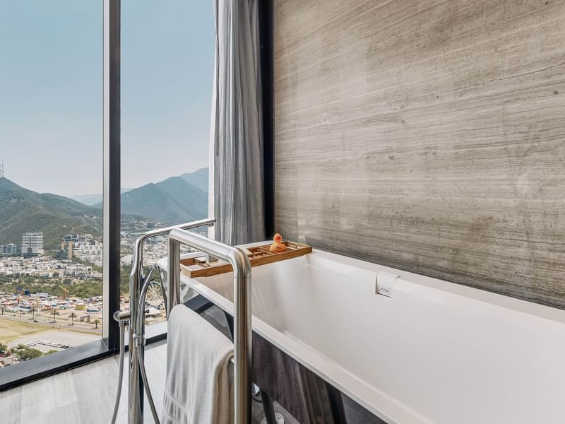 Bathtub by the window with mountain view in Deluxe Room Dog Friendly at Live Aqua Monterrey
