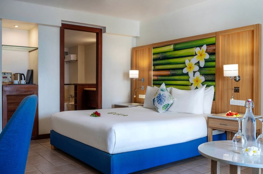 White bed by a marble table near an open doorway surrounding a bathroom in King Suite Ocean View at The Naviti Resort - Fiji