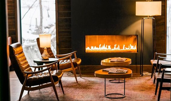 Fireplace with four chairs at Hay Creek Hotels