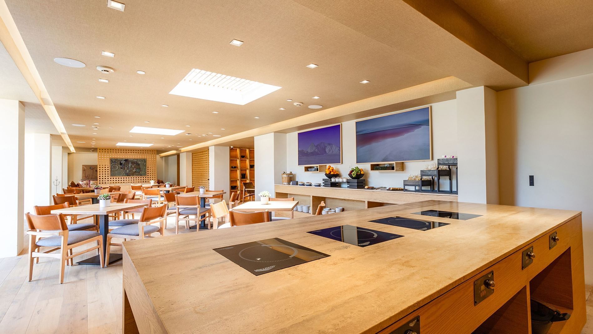 Modern buffet and lounge area with wooden tables and sleek digital screens at Camino Real Hotels