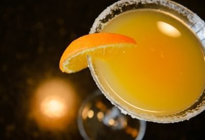 Yellow cocktail garnished with sliced orange in a sugar-rimmed martini glass at Clemson University Conference Center & Inn
