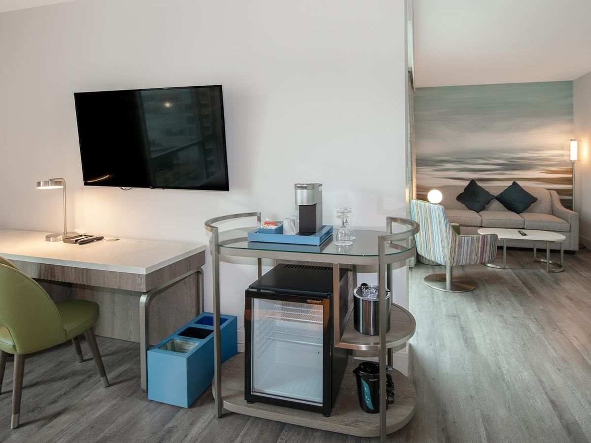 Elegant room with desk, chair, mini-fridge, and king bed.