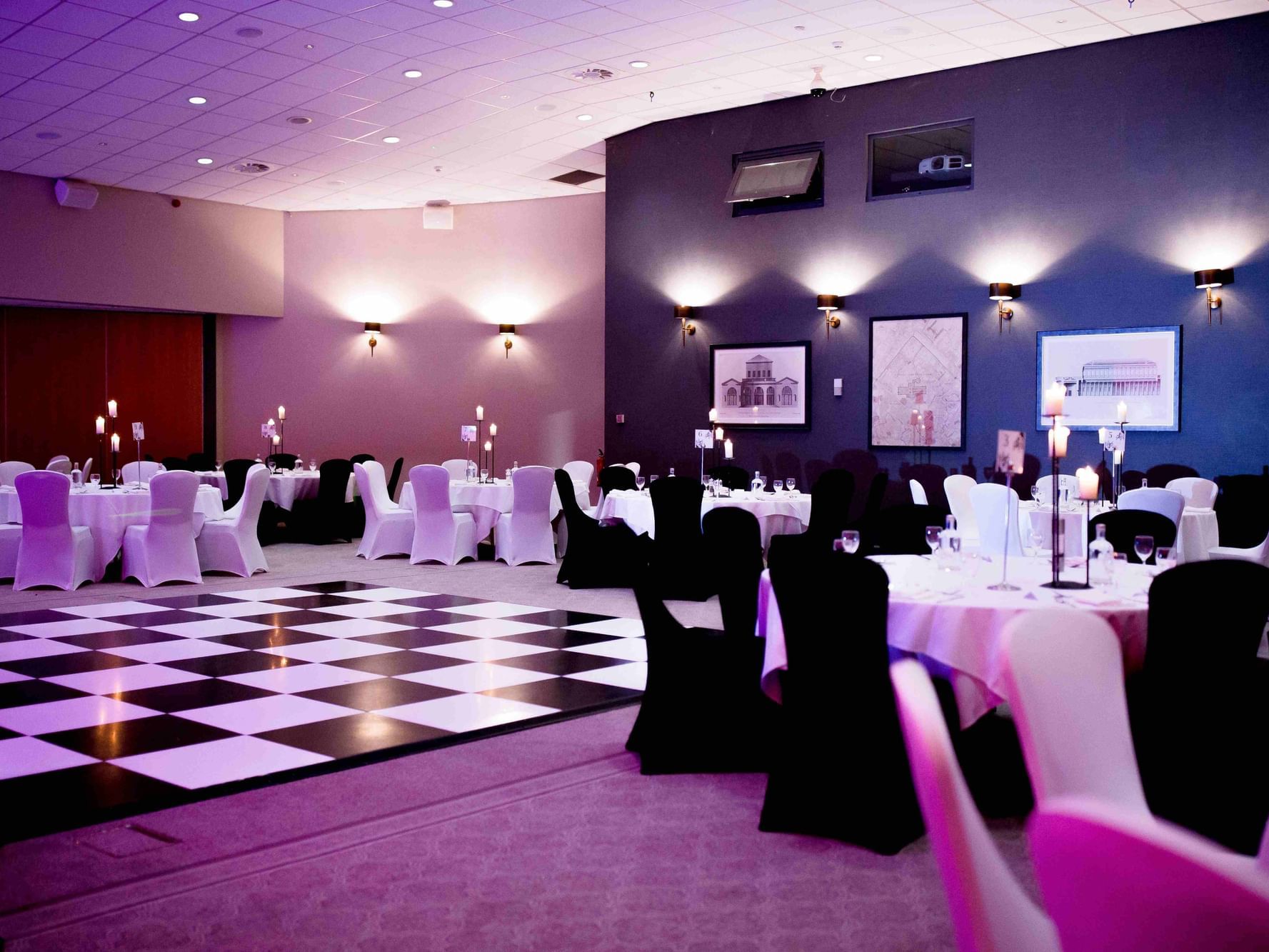 Banquet hall with white-covered tables, checkered dance floor, and soft lighting at The Milner York