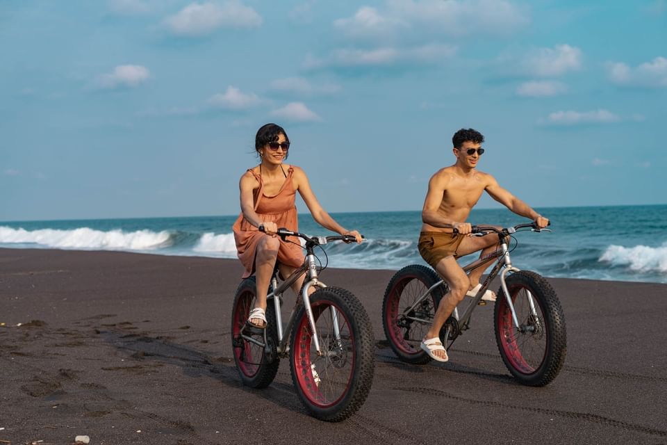 A couple riding bikes by the beach at La Mar Monterrico