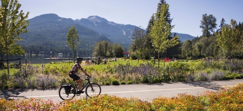 Cyclist riding the Valley Trail beside Alta Lake in Whistler