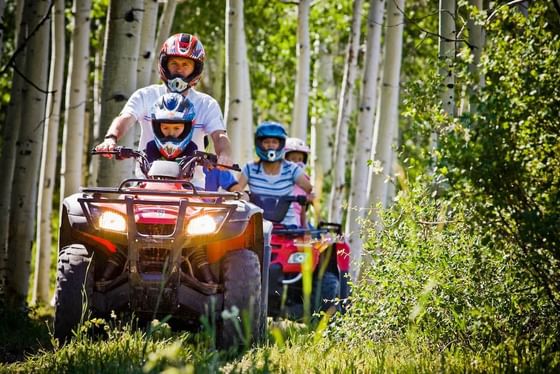 Group of people riding quad bike near Stein Eriksen