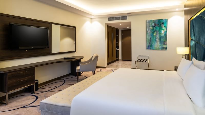Deluxe Room with cozy bed and TV at Warwick Riyadh 