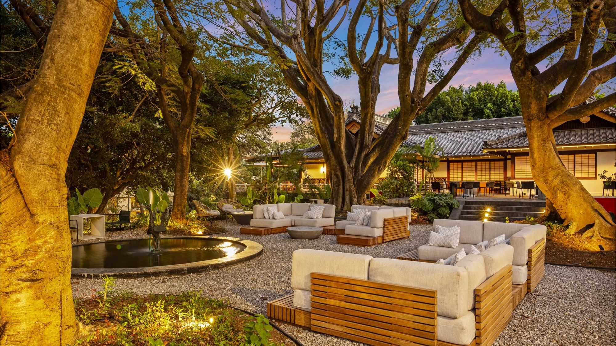 Outdoor seating area with wood furniture and fire pit at Grand Fiesta Americana Sumiya Cuernavaca.