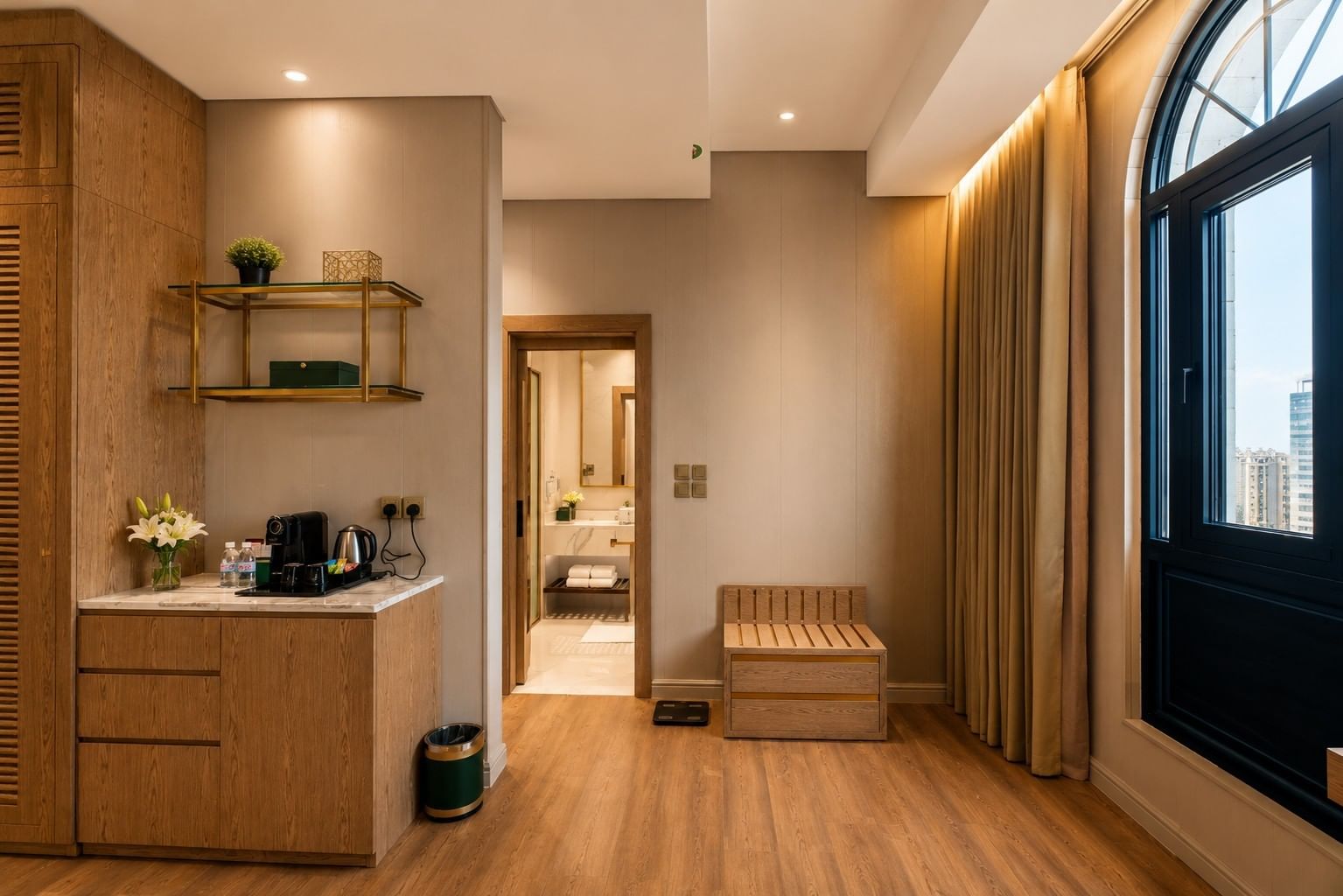 Wooden minibar station and luggage bench near arched window in Deluxe skyline view at Naviti by Warwick Jeddah