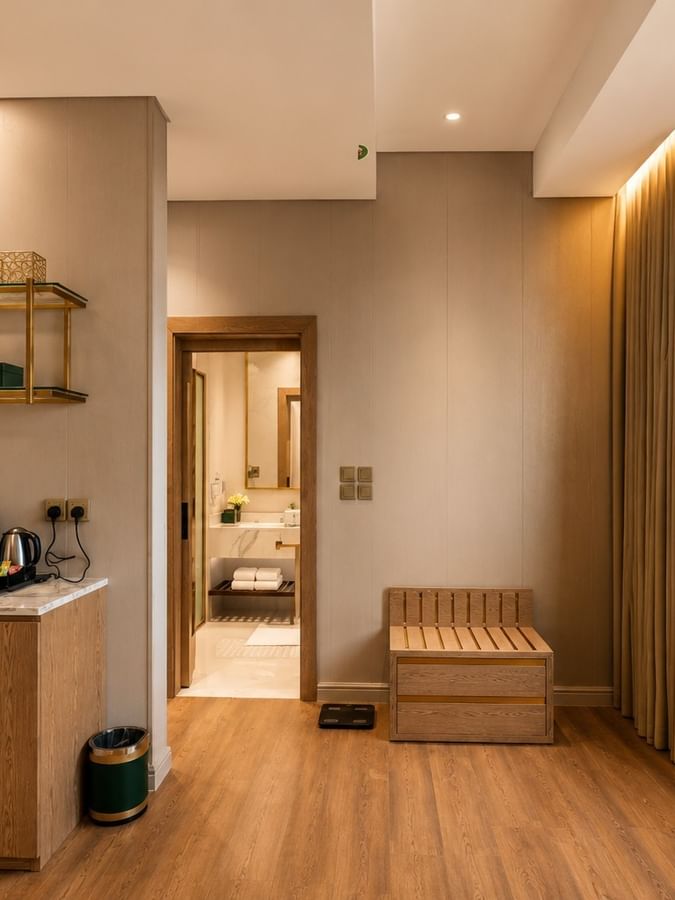 Wooden minibar station and luggage bench near arched window in Deluxe skyline view at Naviti by Warwick Jeddah