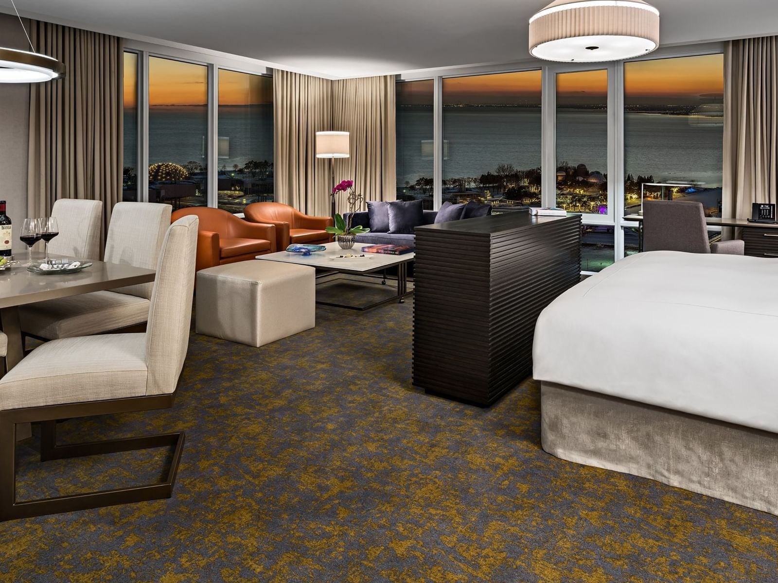 Dining and seating area with ocean view at sunset in Two Bedroom Junior Suite by Hotel X Toronto