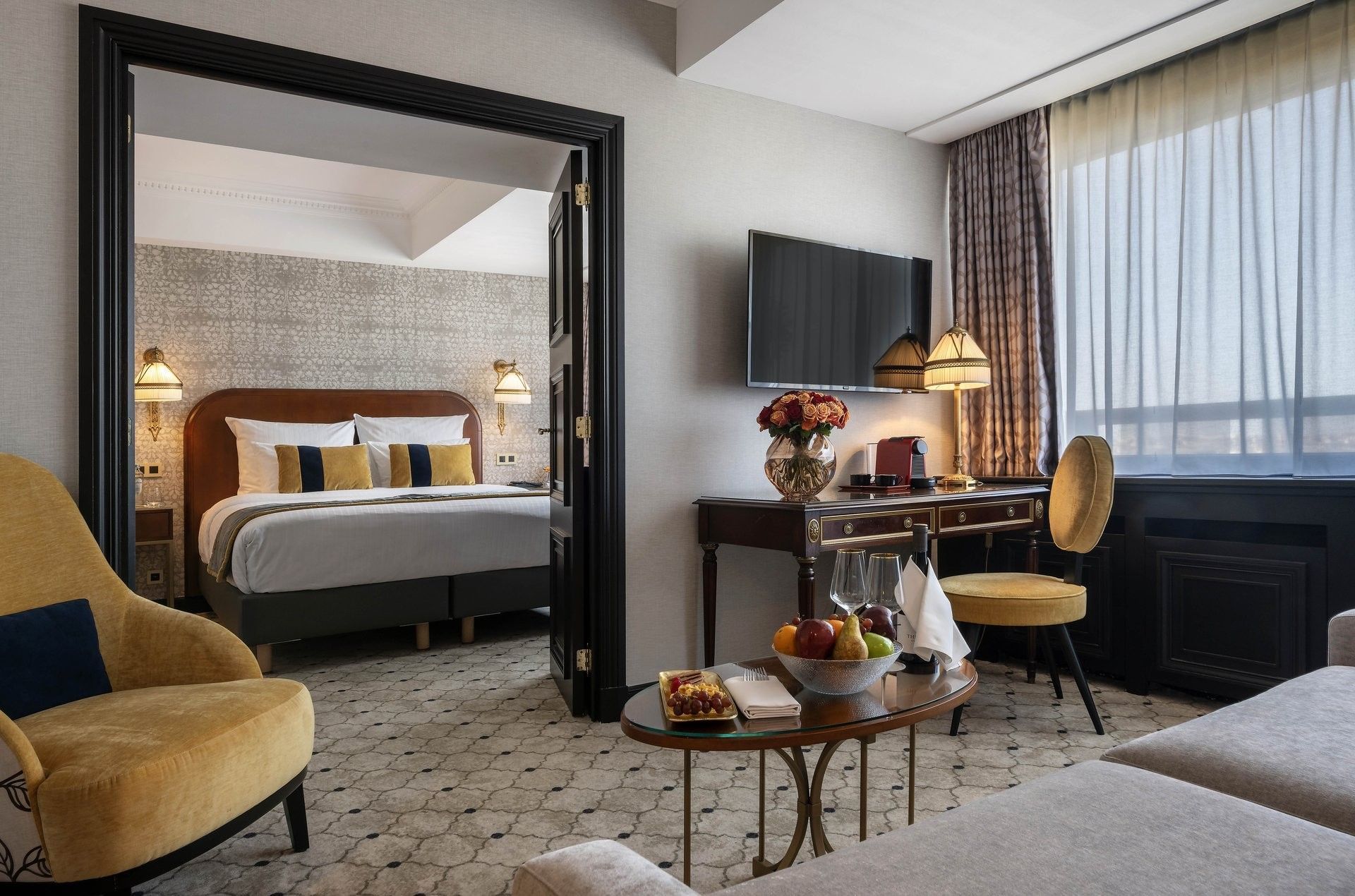 Living area with fruit bowl & yellow chair looking into the bedroom in Warwick Suite with terrace at Hotel Barsey by Warwick
