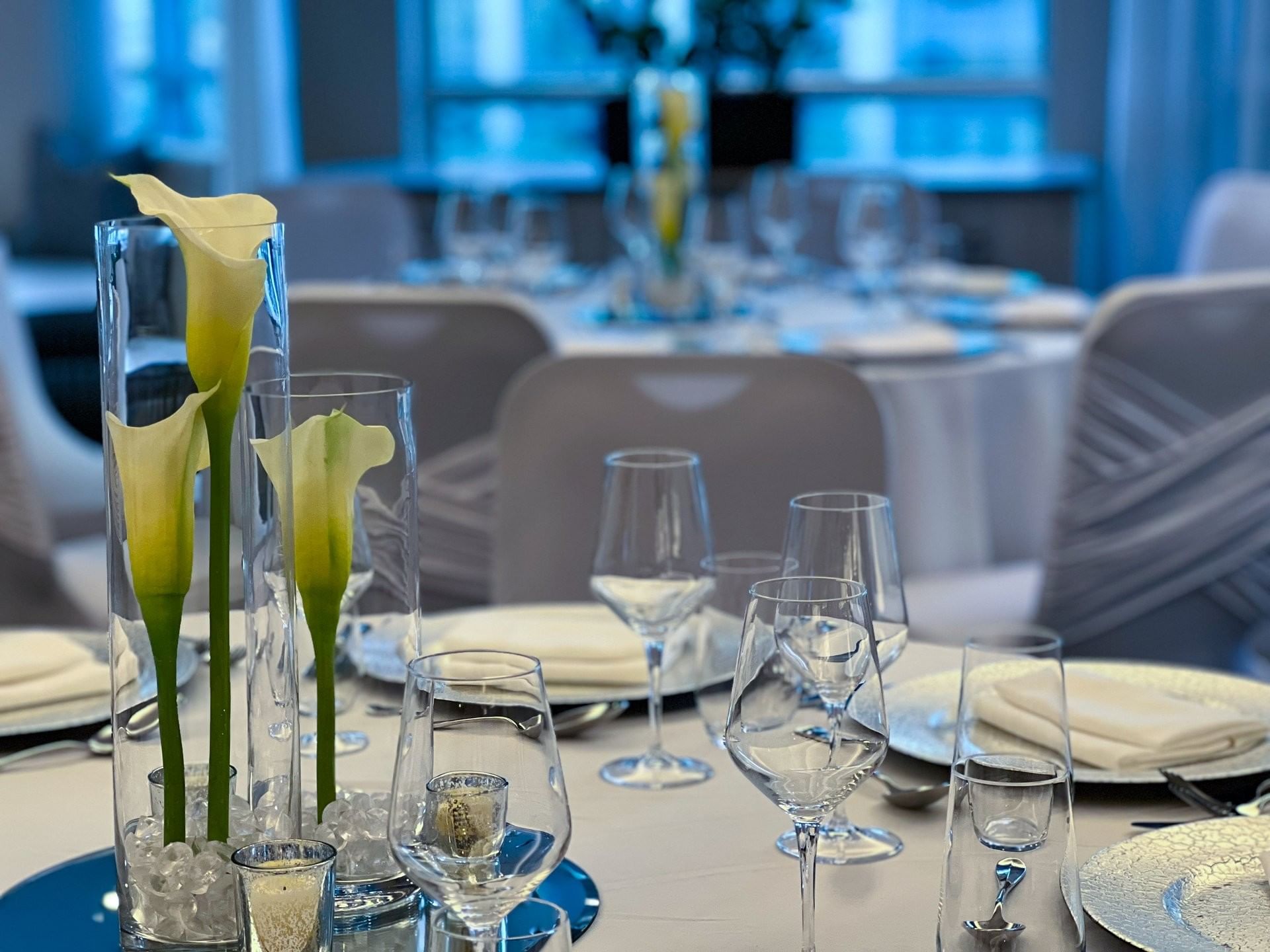 Decorated dining table with Calla Lily centerpieces and glasses at Warwick Le Crystal Montreal