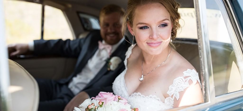 A bride and groom arrive at their elopement venue in Canmore in a classic car.