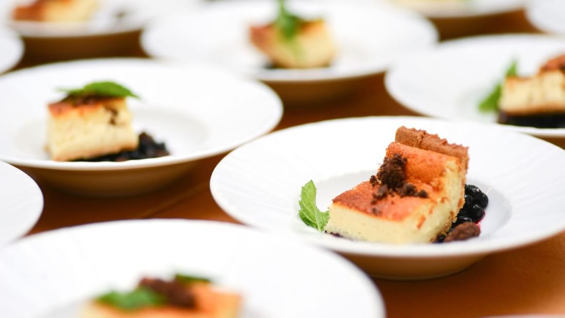 Slices of cheesecake garnished with mint on white plates at Mercure Hotel Townsville