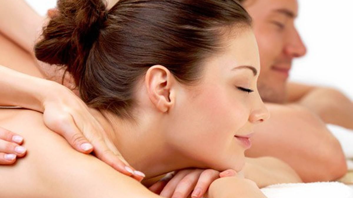 Une femme reçoit un massage au cou et à l'épaule par un massothérapeute dans un spa.