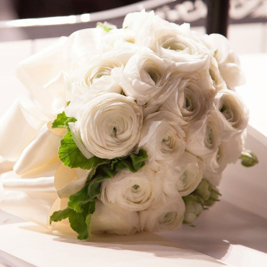 Elegant white ranunculus bridal bouquet on a table at The Terraces Resort & Spa