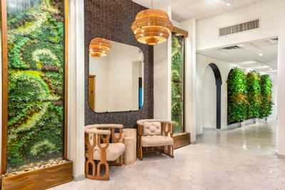 Stylish lobby at The Riverwalk Plaza Hotel with lush vertical gardens, modern decor, brass chandeliers, and elegant seating