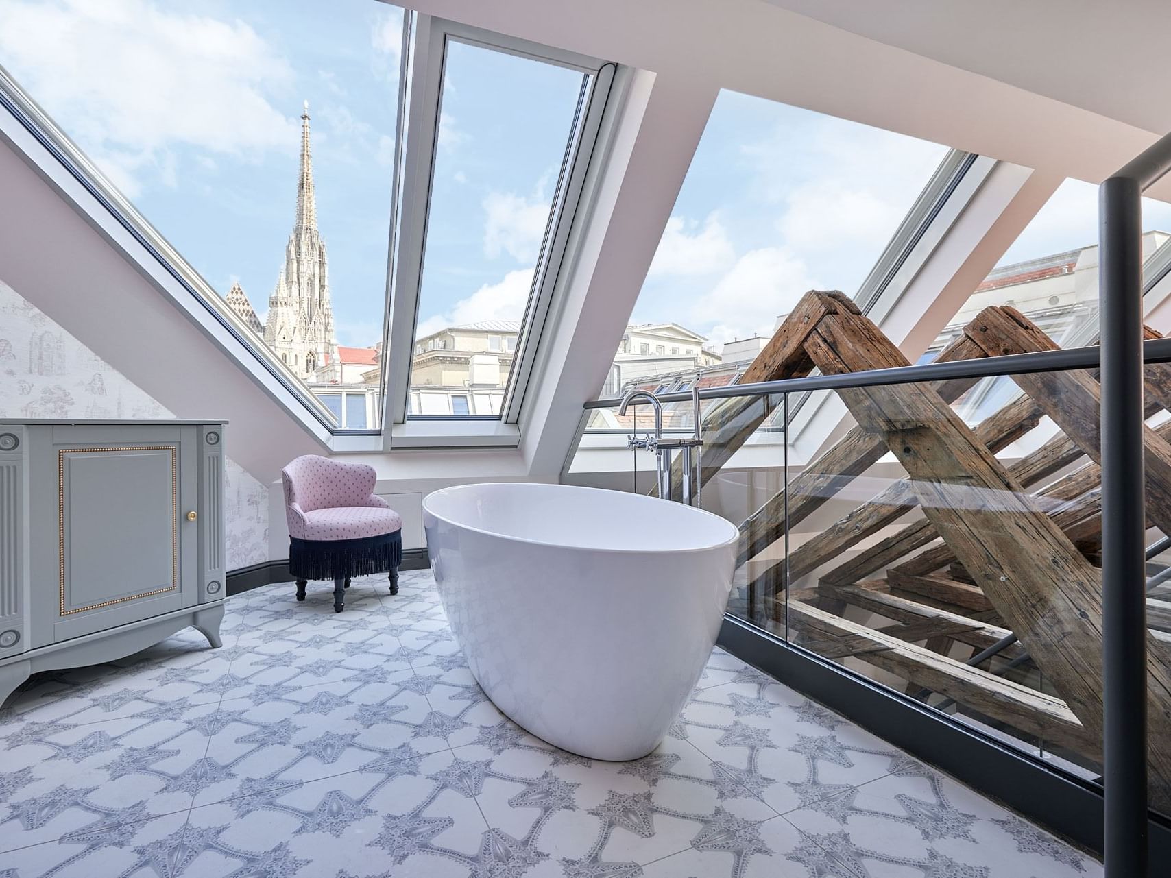 Leopold Suite bathroom with a freestanding bathtub, glass shower, and large windows showing a cityscape.