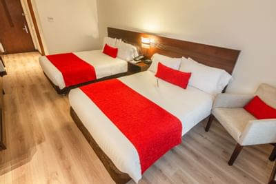 A room with two double beds and other room amenities