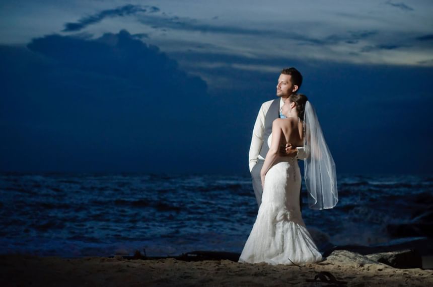 Bride and groom take a dramatic photo on the beach at our Diamond Beach wedding venue